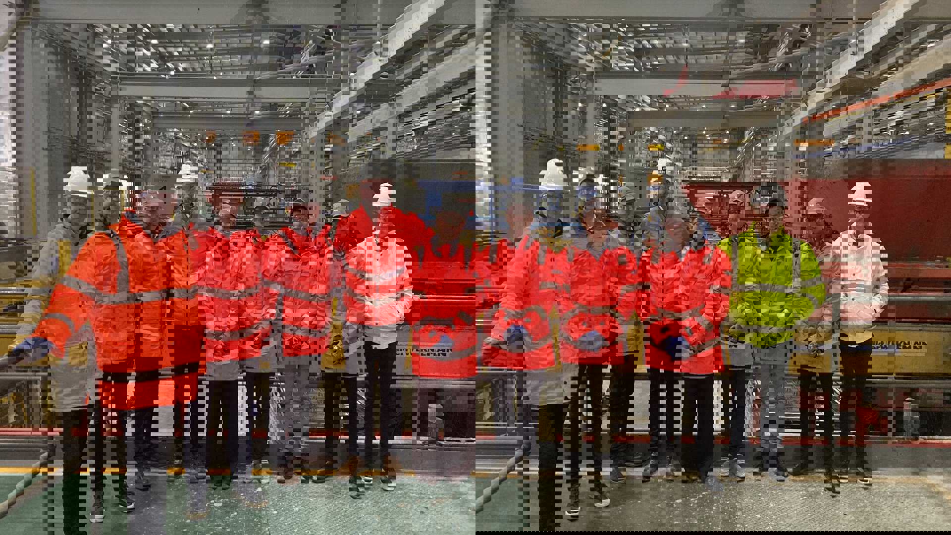 People in hi-vis and hard hats on a site tour of a logistics building